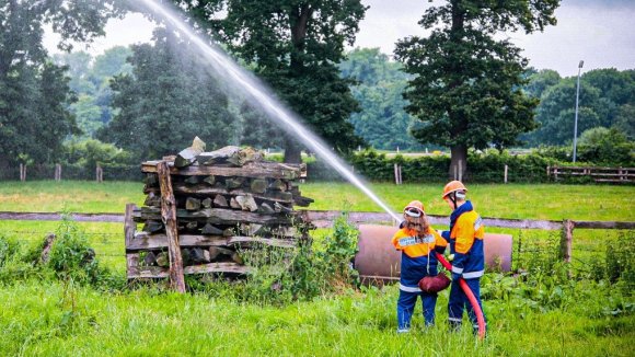 Feuerwehrleute mit einem Löschschlauch